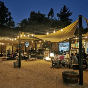 Vista del restaurante Kochü en Vichuquén con personas disfrutando del ambiente y la comida frente al Lago