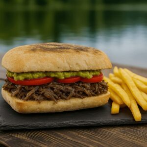 Sándwich Mechada Italiana con tomate, palta y mayonesa, acompañado de papas fritas en Kochü, restaurante en Vichuquén con vista al Lago